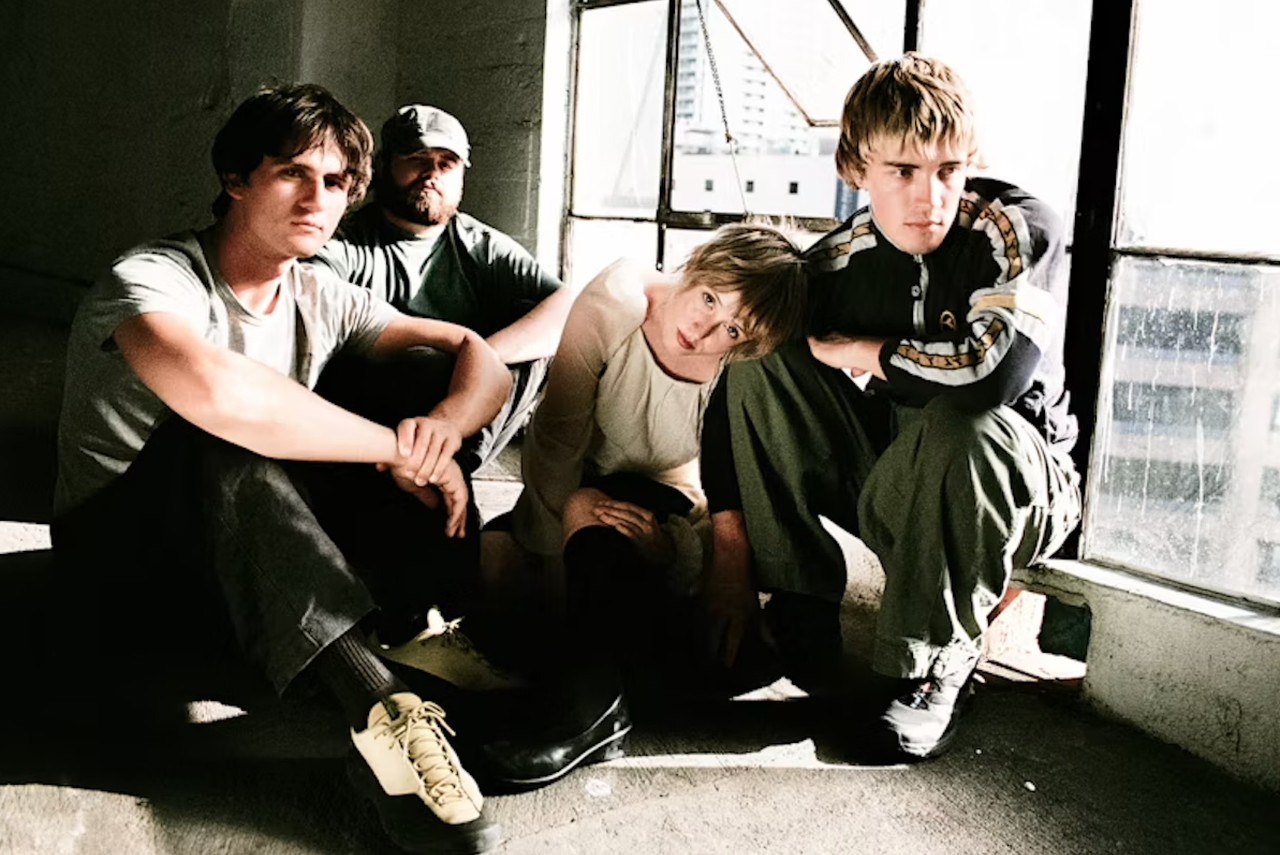 Australian indie rock band Swapmeet crouching near a large window.